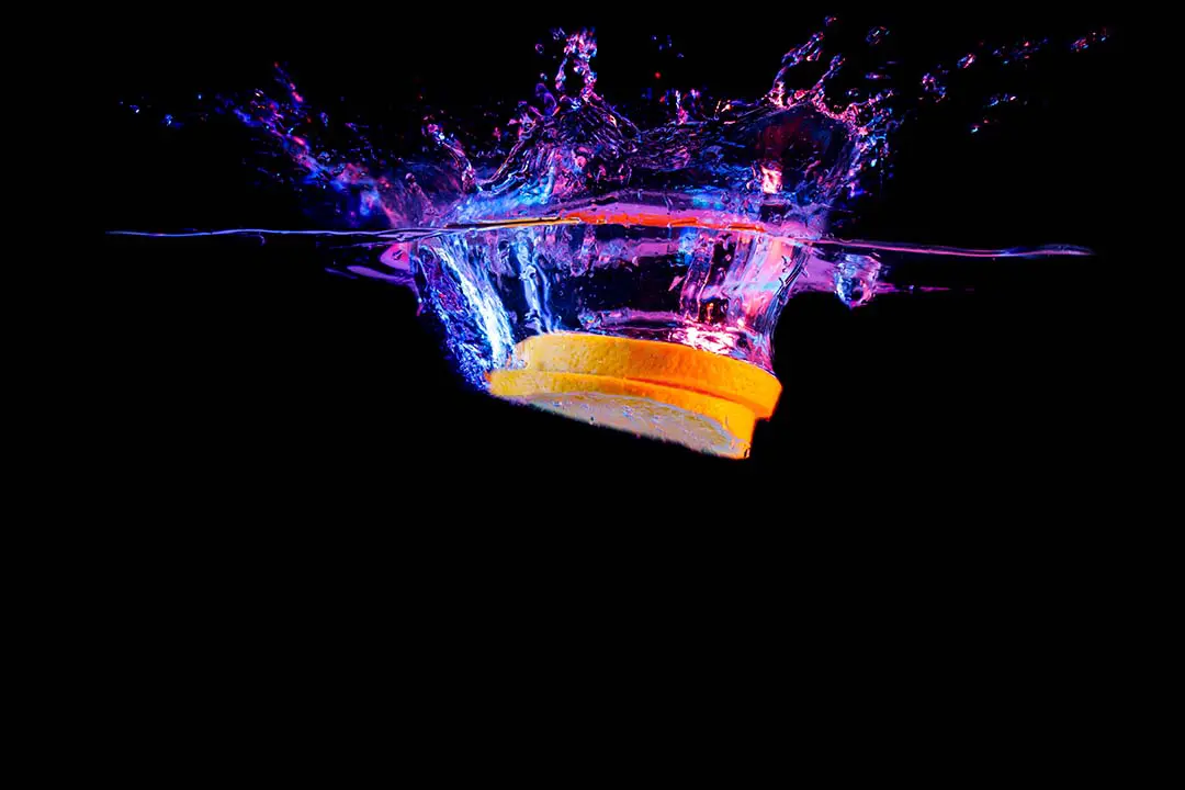 splashy orange einzelne orangen scheibe mit farbigem wasser